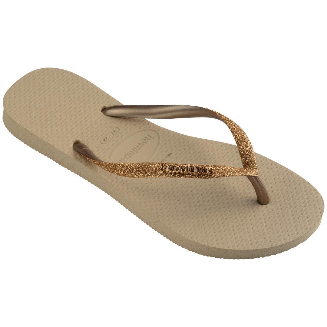 Chinelo Havaianas Slim Glitter II em perspectiva inclinada destacando a tira frontal com glitter bronze e palmilha com logo.